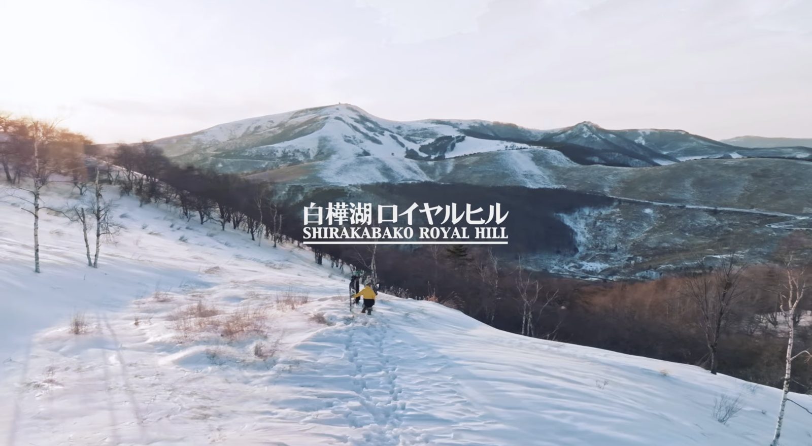 雪山を登る人と白樺湖周辺の山並み